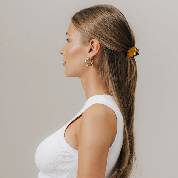 Profilansicht einer Frau mit glatten, offenen Haaren, zurückgesteckt mit unserer Mini-Haarklammer in Tortoise (3,5 cm) – elegant und alltagstauglich gestylt.